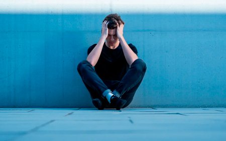 Парень сидит у стены